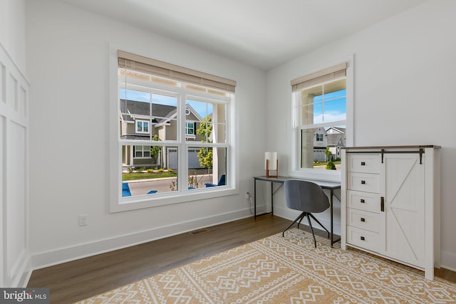 office space featuring a barn door and light hardwood / wood-style flooring