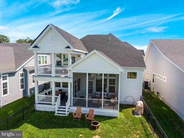 back of house with a sunroom, a balcony, a yard, and central AC