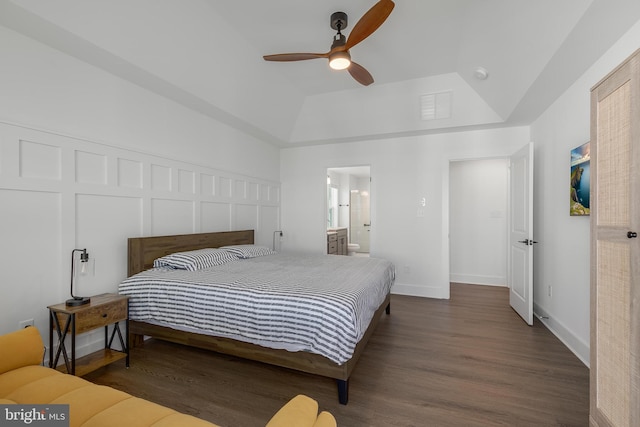 bedroom with a tray ceiling, connected bathroom, ceiling fan, and dark hardwood / wood-style floors