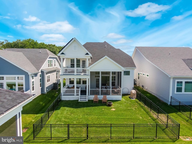 rear view of property with a sunroom, a balcony, and a yard