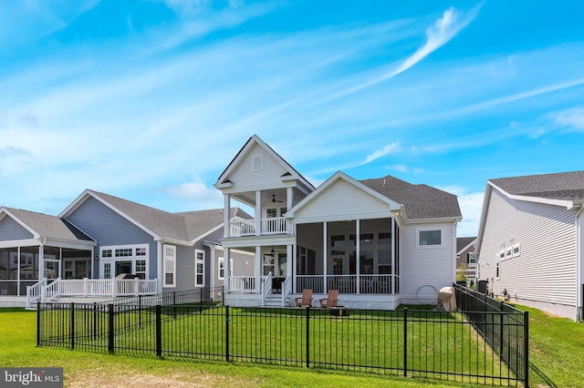 rear view of property featuring a lawn and a sunroom