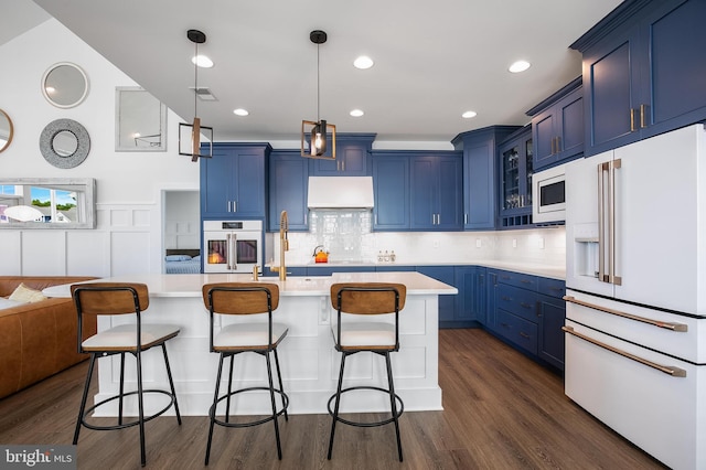 kitchen featuring blue cabinetry, white appliances, extractor fan, and a kitchen island with sink