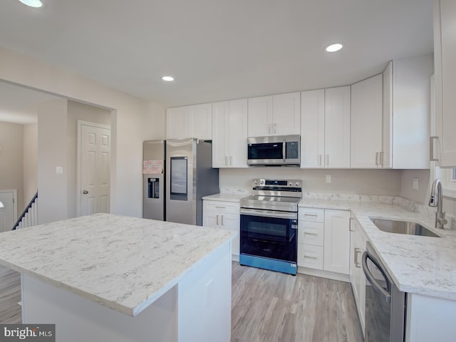 kitchen with a kitchen island, sink, white cabinetry, and stainless steel appliances