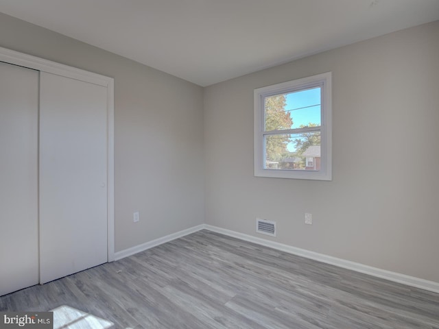 unfurnished bedroom featuring a closet and light hardwood / wood-style flooring