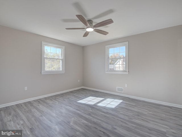 unfurnished room featuring ceiling fan, light hardwood / wood-style flooring, and a healthy amount of sunlight