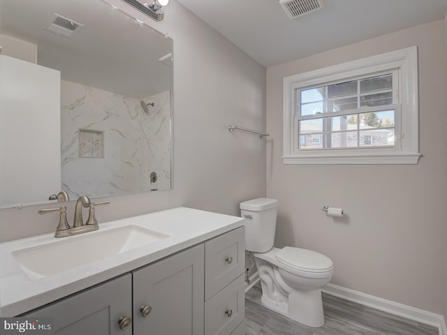 bathroom with a shower, wood-type flooring, vanity, and toilet