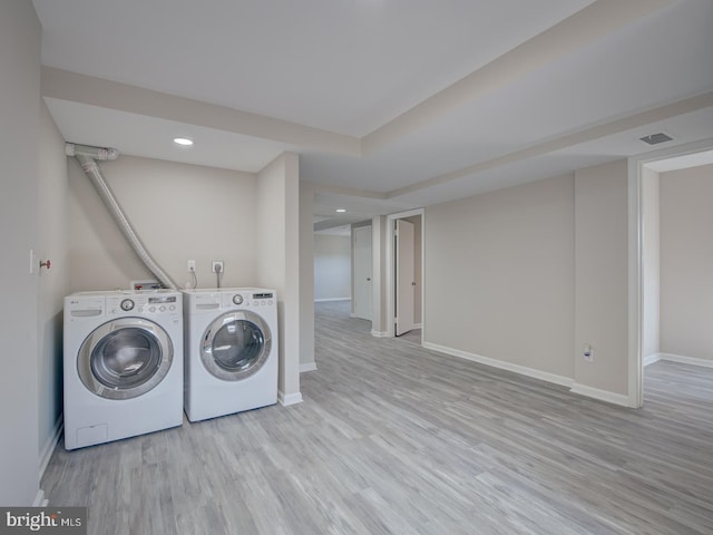 laundry area with washer and dryer and light wood-type flooring