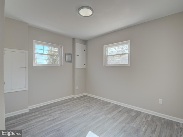 unfurnished room with light wood-type flooring and a healthy amount of sunlight