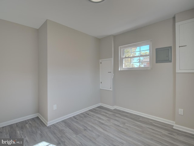 unfurnished room featuring light hardwood / wood-style floors and electric panel