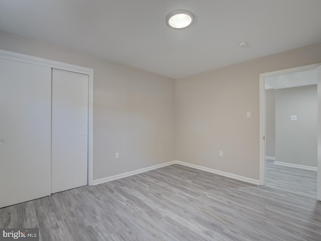 unfurnished bedroom with a closet and light hardwood / wood-style flooring