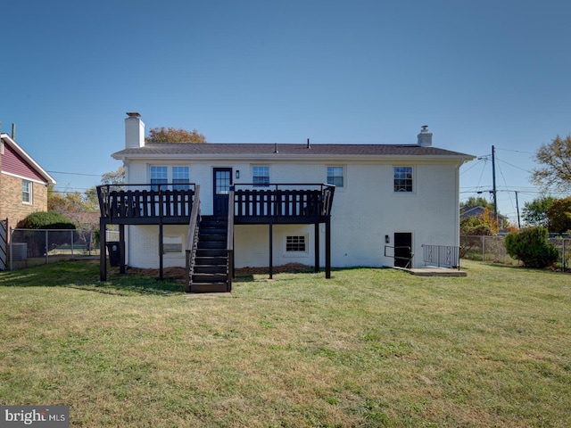 rear view of house featuring a lawn and a deck