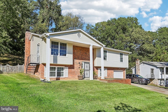 split foyer home featuring a front lawn and a garage