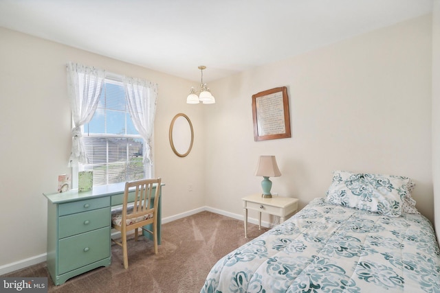 carpeted bedroom featuring an inviting chandelier