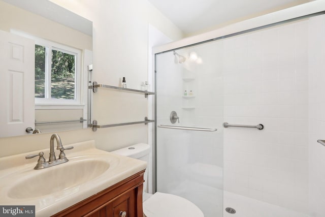 bathroom with toilet, walk in shower, and vanity