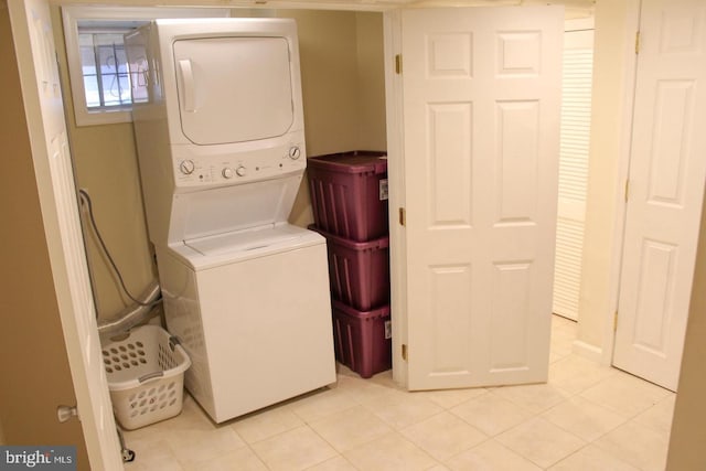 clothes washing area featuring stacked washer / drying machine and light tile patterned floors