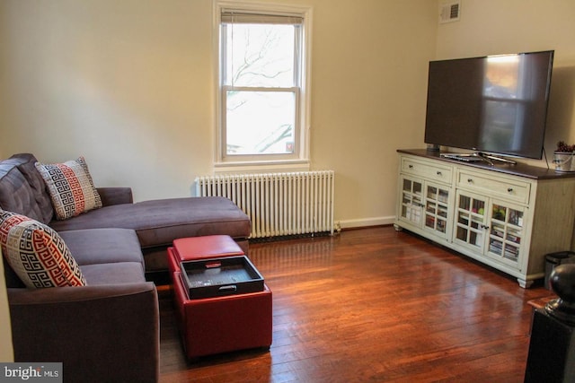 living room with radiator heating unit and dark wood-type flooring