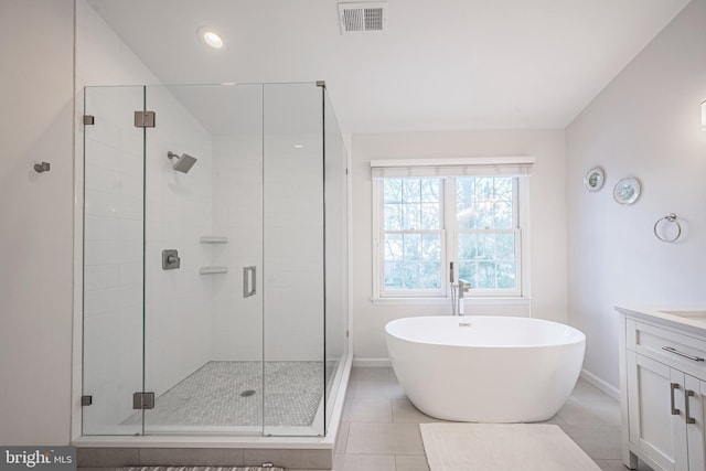 bathroom with tile patterned flooring, separate shower and tub, and vanity