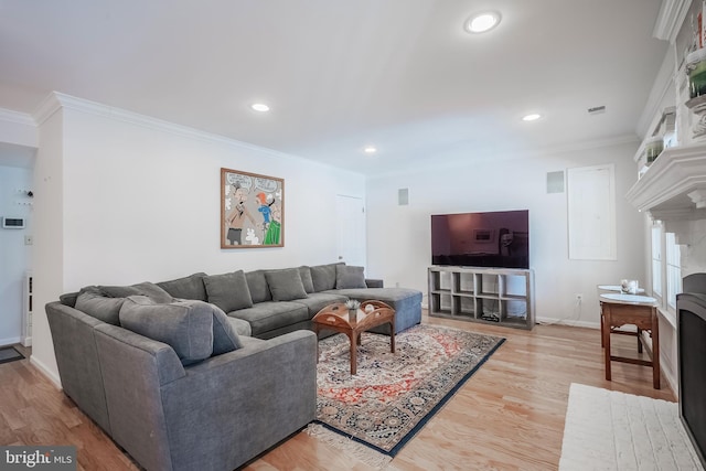 living room featuring a brick fireplace, crown molding, and hardwood / wood-style flooring