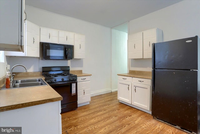 kitchen with white cabinets, light wood-type flooring, black appliances, and sink