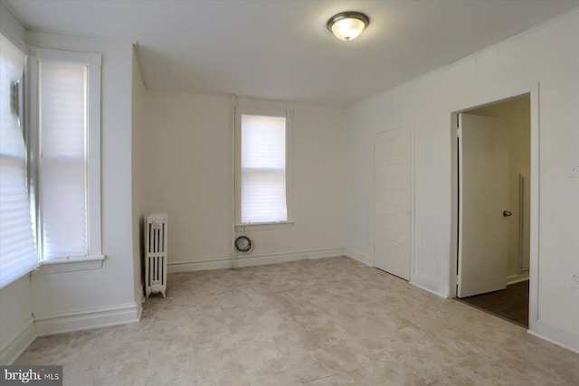 spare room featuring radiator and a wealth of natural light