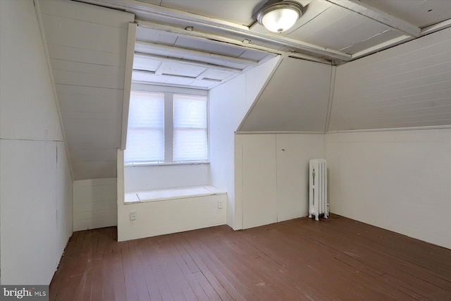 bonus room with hardwood / wood-style floors, radiator heating unit, and vaulted ceiling