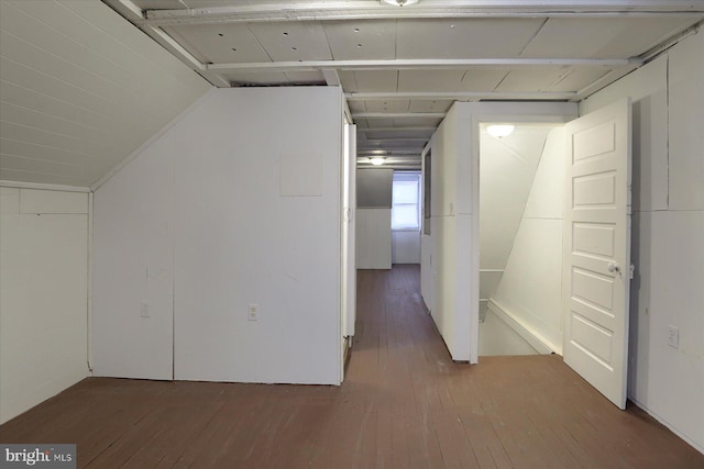 corridor with hardwood / wood-style flooring and vaulted ceiling