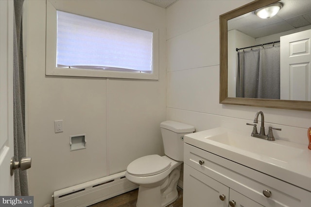 bathroom with toilet, a shower with shower curtain, vanity, and a baseboard heating unit