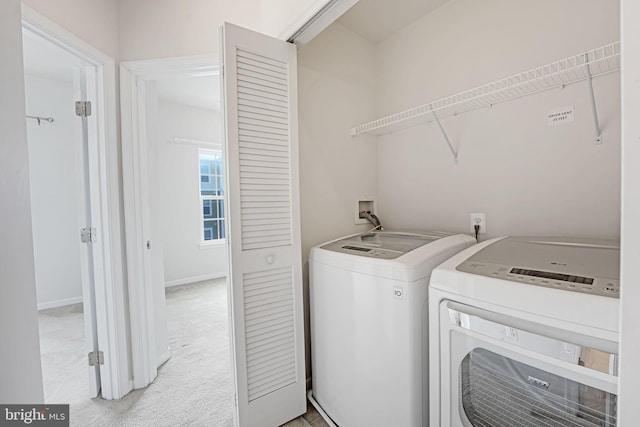 laundry area featuring light carpet and washing machine and clothes dryer