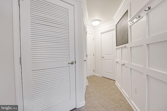 hall featuring light tile patterned flooring and ornamental molding