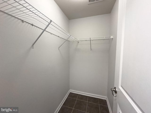 spacious closet featuring dark tile patterned flooring