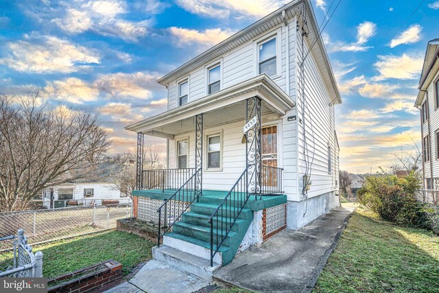 view of front facade with a lawn and a porch