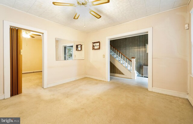 carpeted spare room featuring ceiling fan and radiator