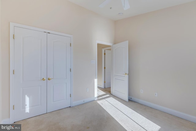 unfurnished bedroom featuring light carpet, ceiling fan, and a closet