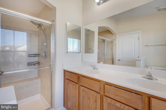 bathroom with a shower with door and vanity