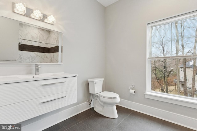 bathroom with vanity, tile patterned floors, toilet, and baseboards