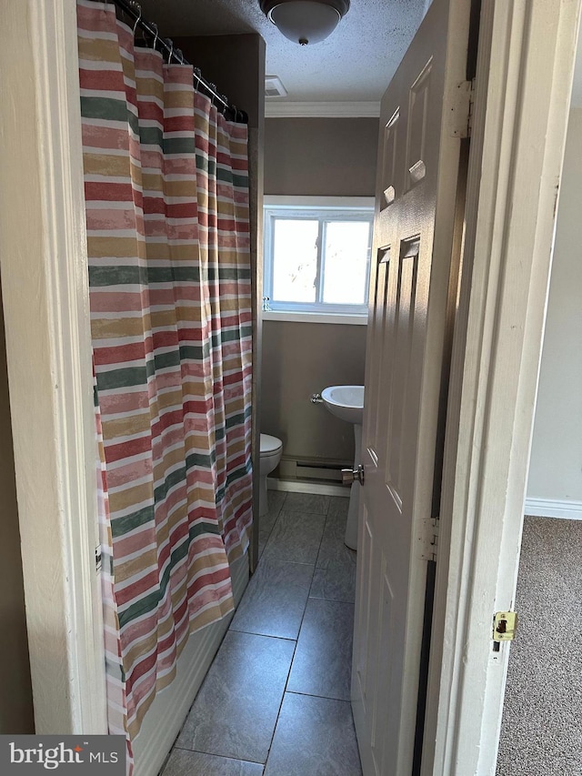 bathroom featuring tile patterned floors, crown molding, a textured ceiling, toilet, and shower / tub combo with curtain