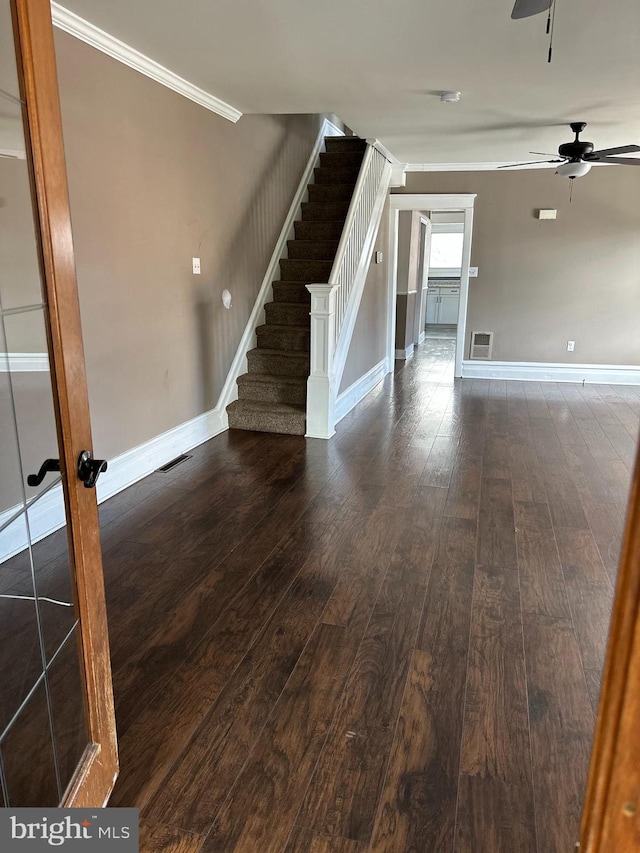 unfurnished room with ceiling fan, dark hardwood / wood-style flooring, and ornamental molding