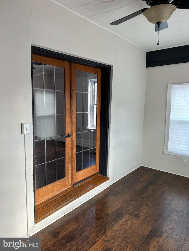 empty room with dark hardwood / wood-style floors, ceiling fan, and french doors