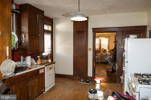 kitchen with hanging light fixtures, white gas stove, a textured ceiling, and light wood-type flooring