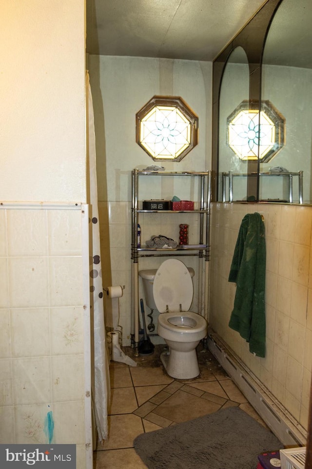 bathroom with tile patterned flooring, a baseboard radiator, and tile walls