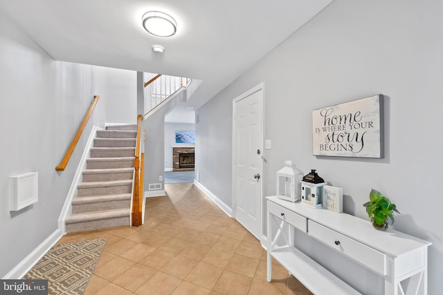 entrance foyer featuring tile patterned floors and a fireplace