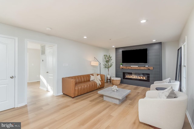 living room with light hardwood / wood-style floors and a fireplace