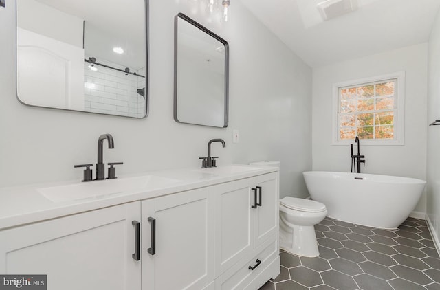 bathroom featuring vanity, toilet, and a tub