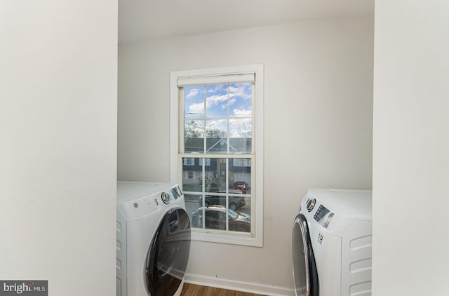 laundry area featuring washing machine and clothes dryer and hardwood / wood-style floors