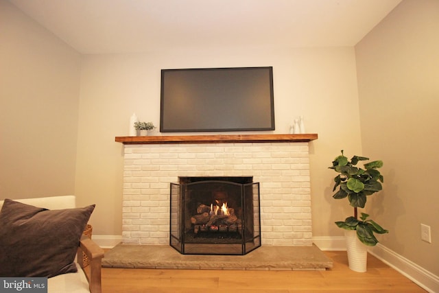 details with a brick fireplace and hardwood / wood-style flooring