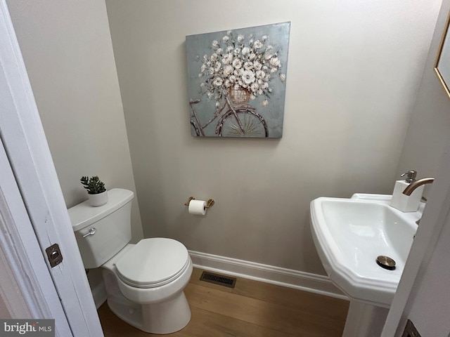 bathroom featuring sink, hardwood / wood-style floors, and toilet