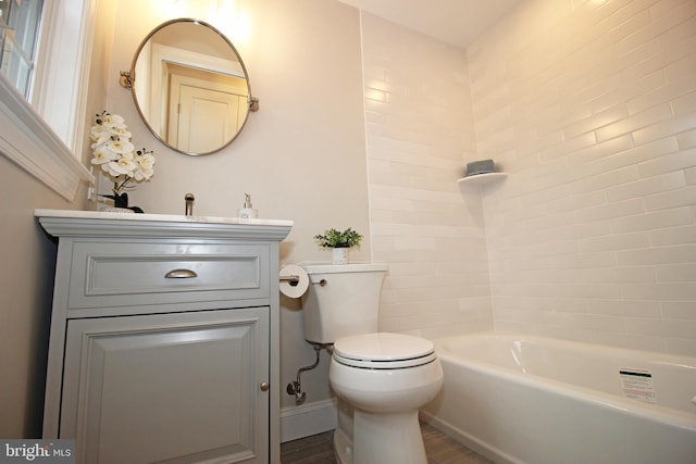 bathroom with toilet, wood-type flooring, vanity, and a tub to relax in