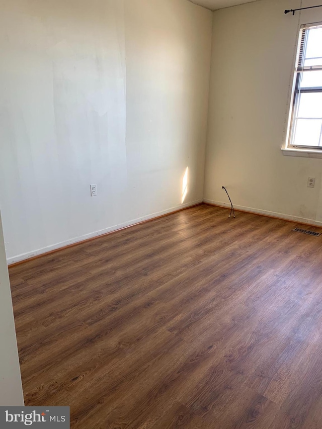 unfurnished room with dark hardwood / wood-style flooring