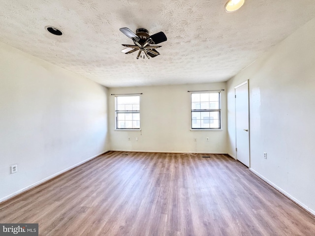 empty room featuring ceiling fan, light hardwood / wood-style floors, and a textured ceiling