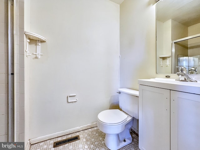 bathroom with tile patterned flooring, walk in shower, vanity, and toilet